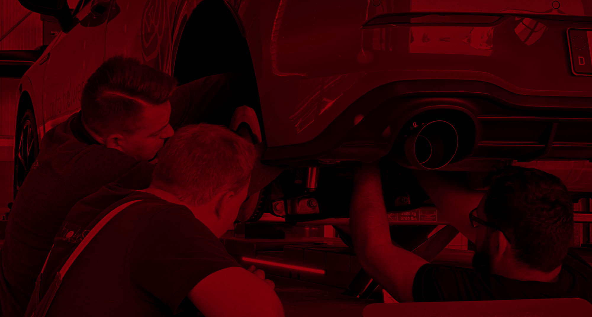 Männer reparieren Fahrzeug auf Hebebühne